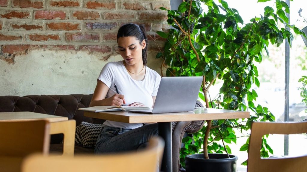 Lady using one of the best laptops for traveling while working in a cafe