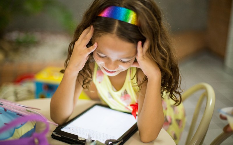 A young girl reading from a tablet