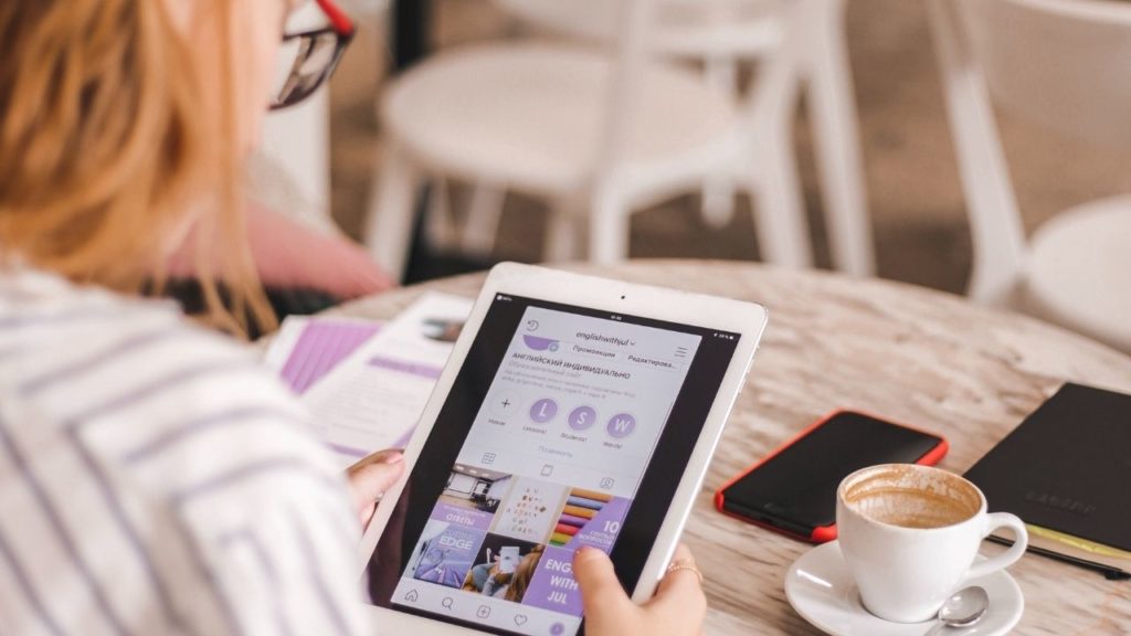 A lady sat in a cafe using the best tablet for traveling that balances performance, price and portability