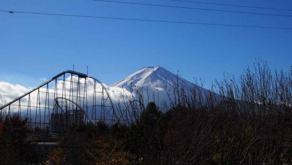 Riding a roller coaster while admiring a great view of Mount Fuji