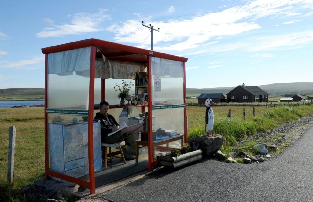 A man sitting at bus stop in Unst, Shetland Islands
