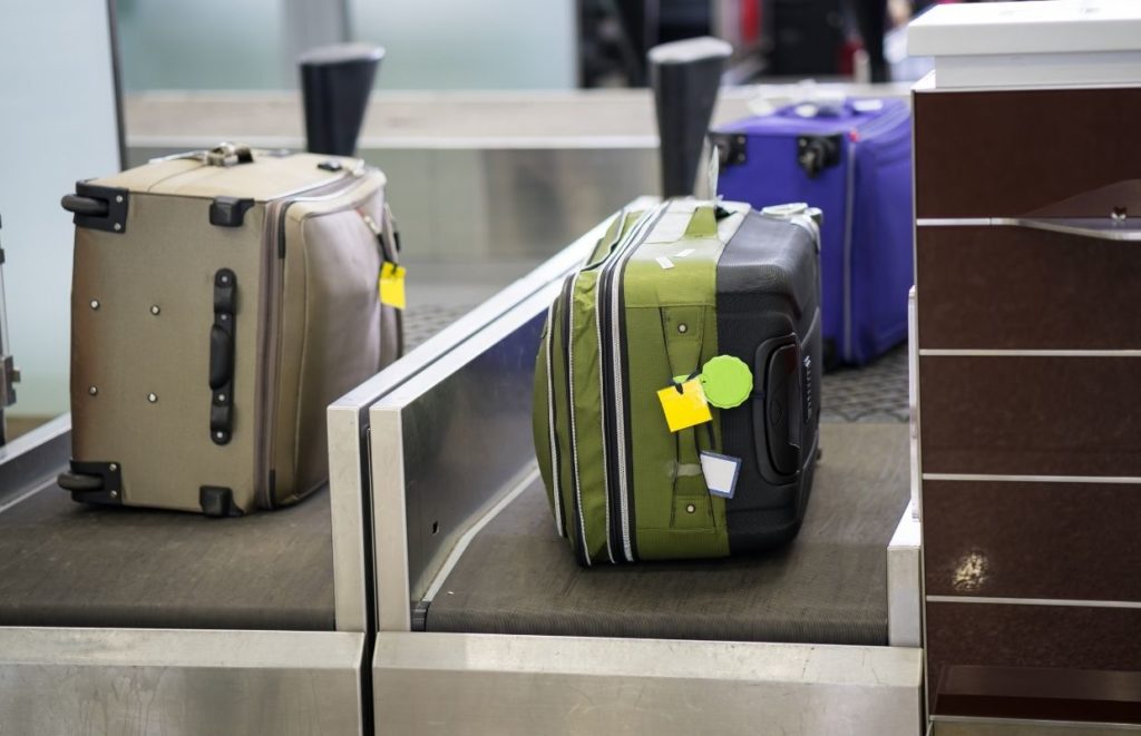 Luggage on the weighing conveyor belt at an airport. Know how heavy your bag is when flying with wine.