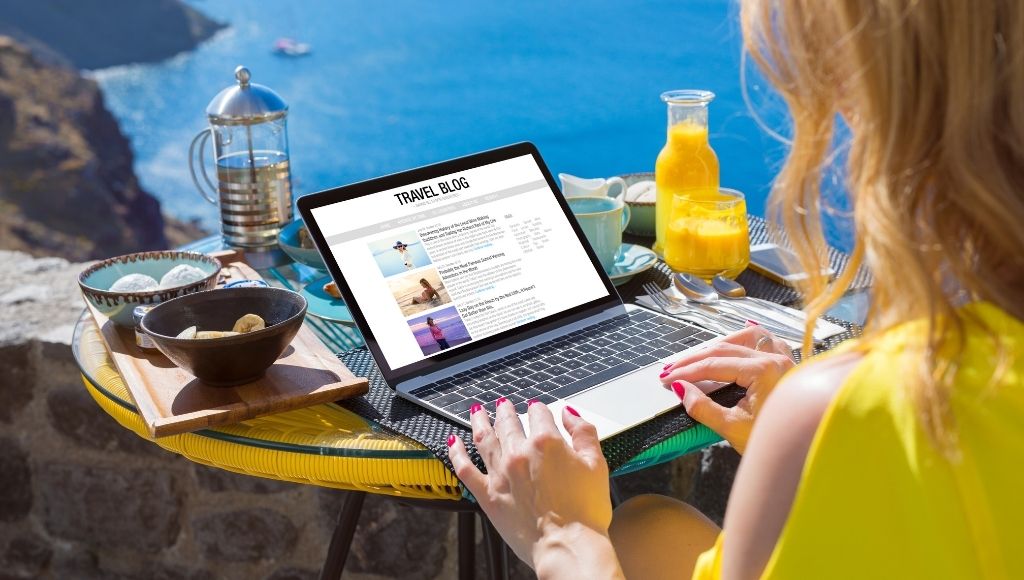 A lady is operating a laptop in a pleasant environment by the sea