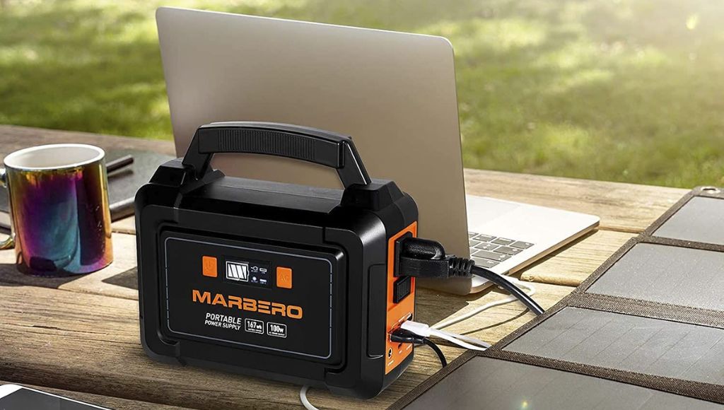 A laptop is being charged with solar generator battery