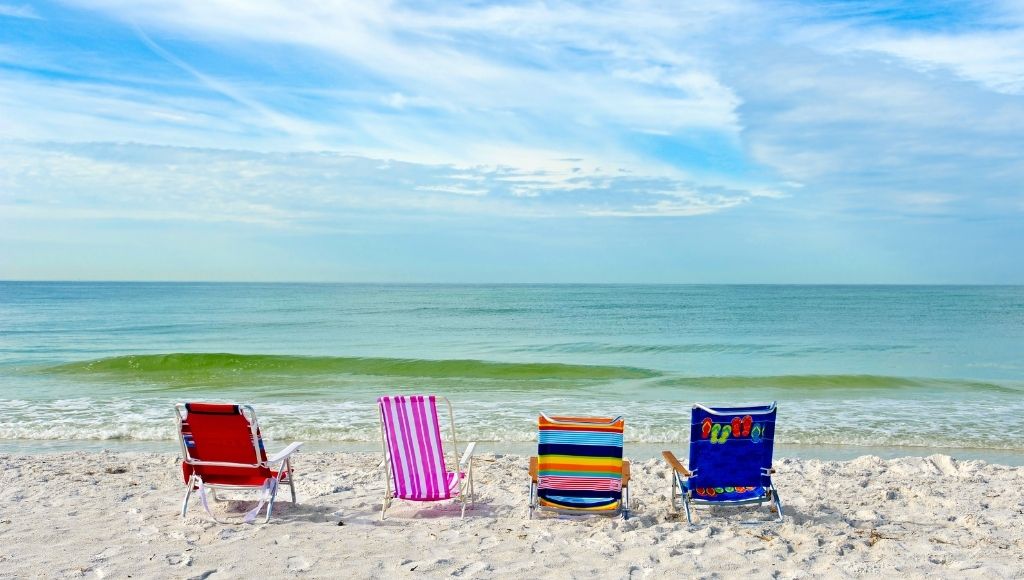 four colorful camping and beach chairs on the beach