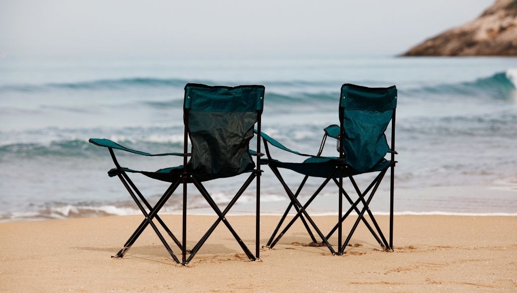 kingcamp chair and strongback elite chairs standing on a beach 