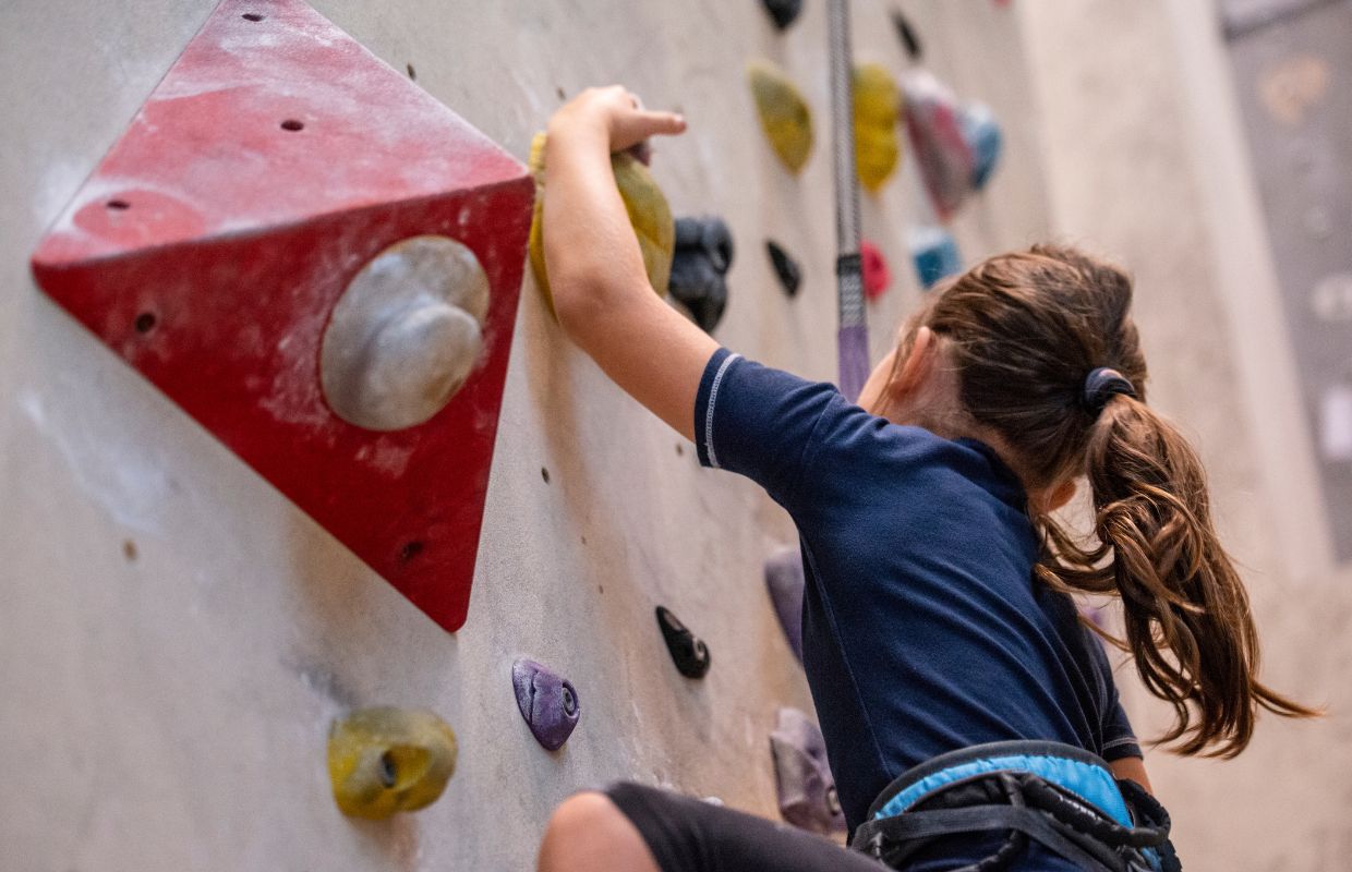 A young girl on an indoor climbing wall