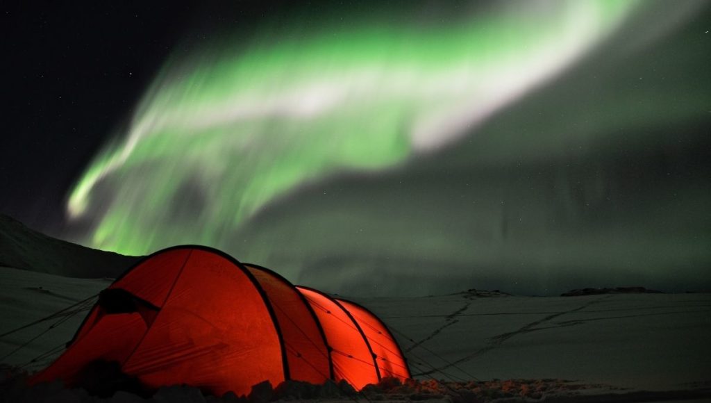 A tent in the snow under the northern lighs