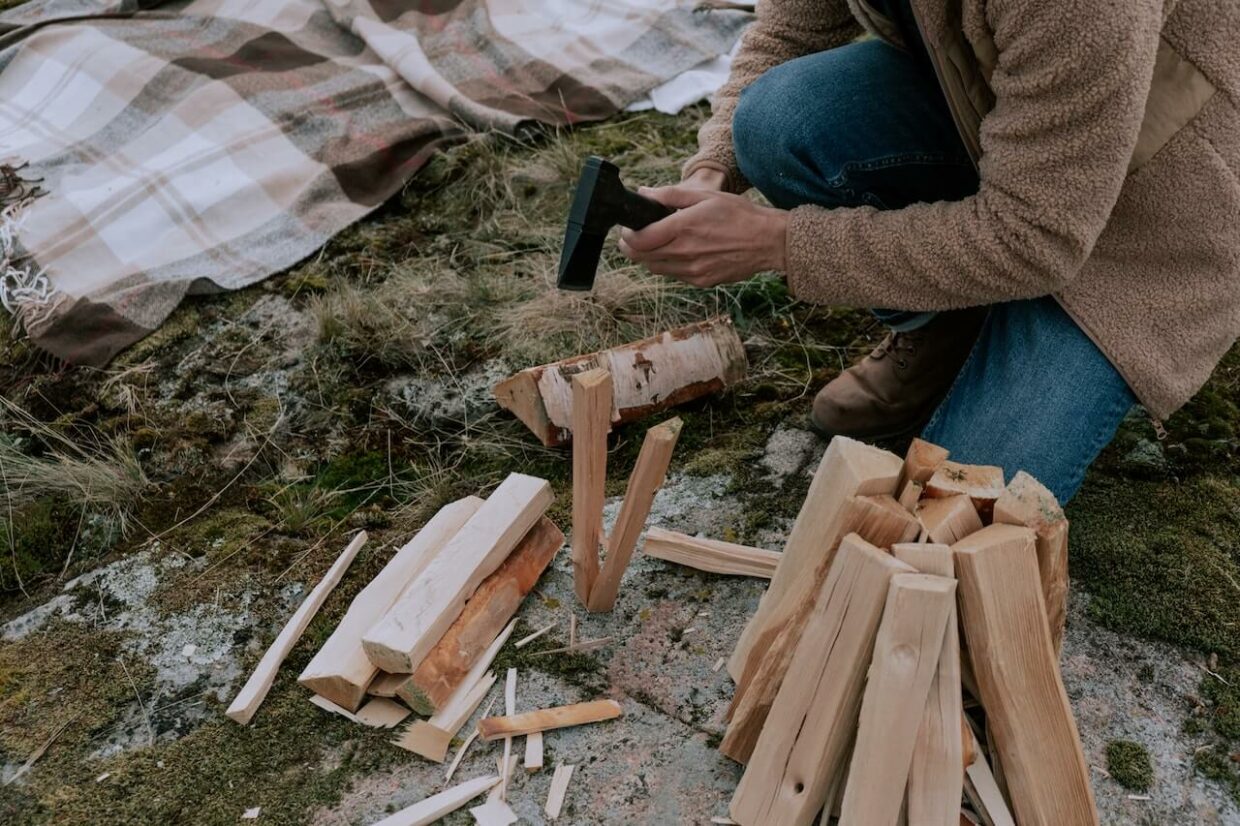 A man using hatchet to fire wood on camping
