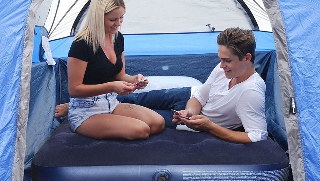 The couple sit on an air mattress in camping