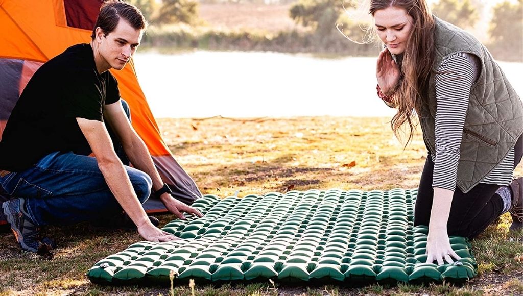 Couple doing setup air mattress in camping
