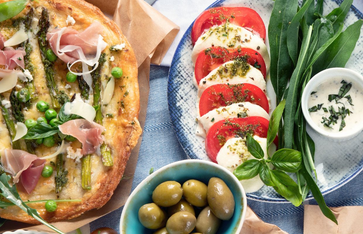 Pizza, olives and a tomato nd mozzarella salad