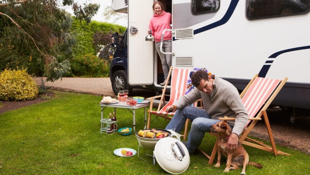 A couple enjoying the best RV BBQ with their dog