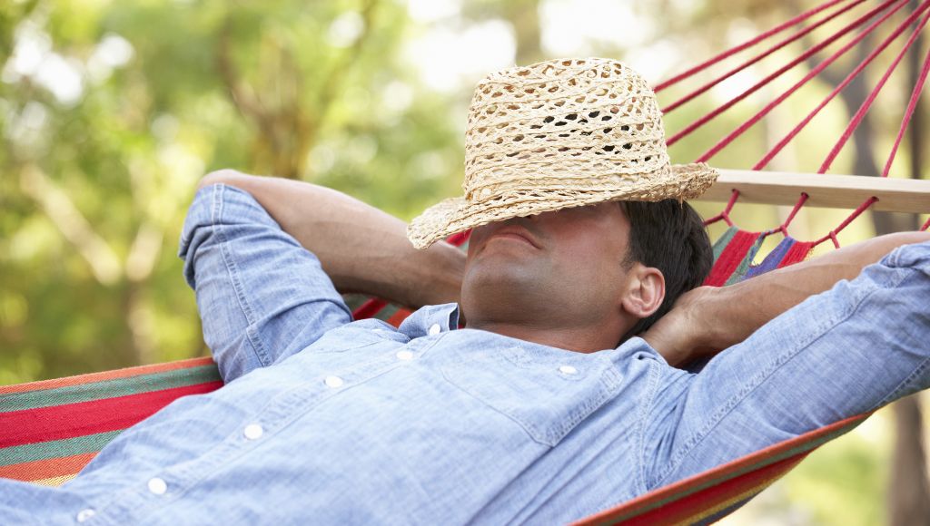 A man is sleeping on a hammock