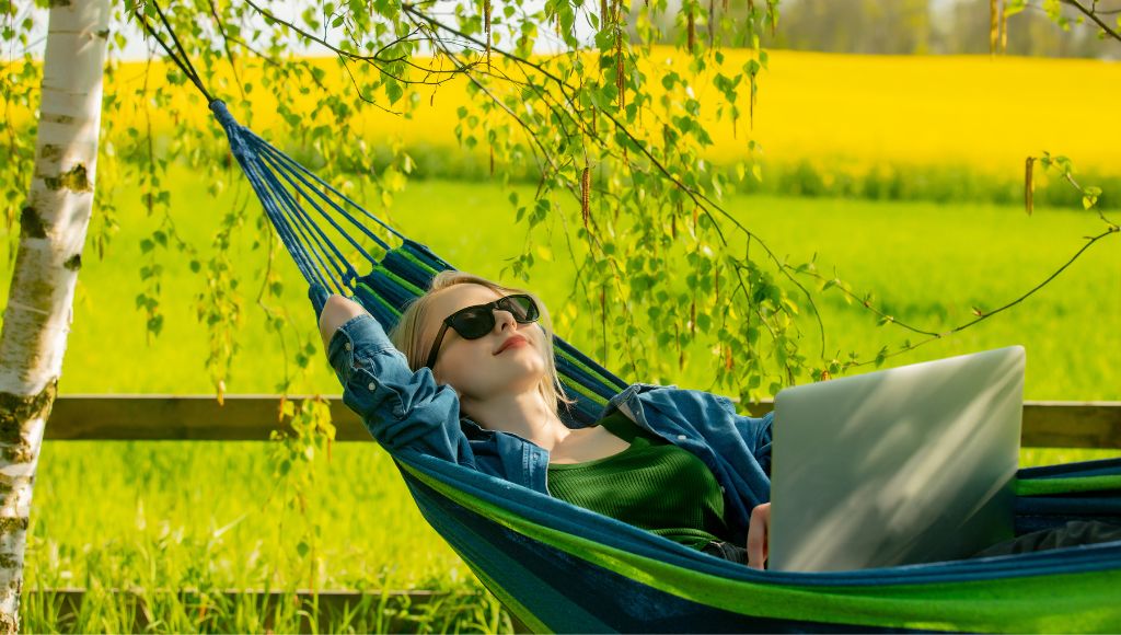 Woman in hammock working with laptop