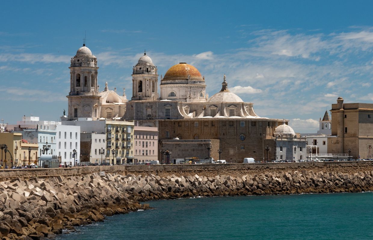 A view of the Cádiz Cathedral tower and dome overlooking the ocean, a must-see attraction in our Cádiz travel guide