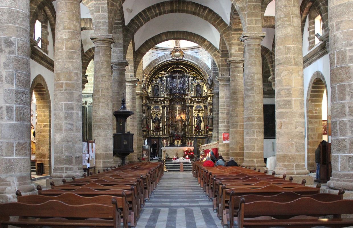 Inside view of Cádiz Cathedral, showcasing the ornate altar and rows of pews, as featured in our Cádiz travel guide