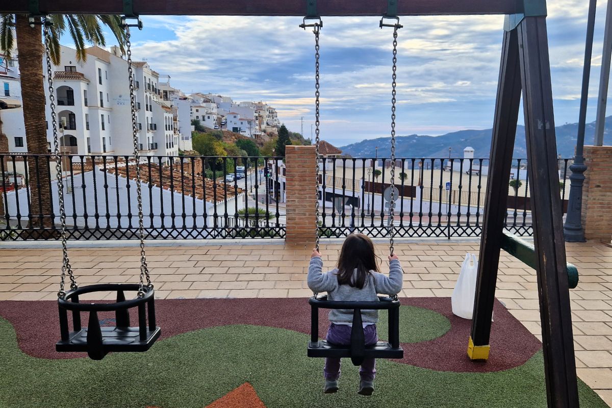My daughter watching the world go by from her swing in Frigiliana
